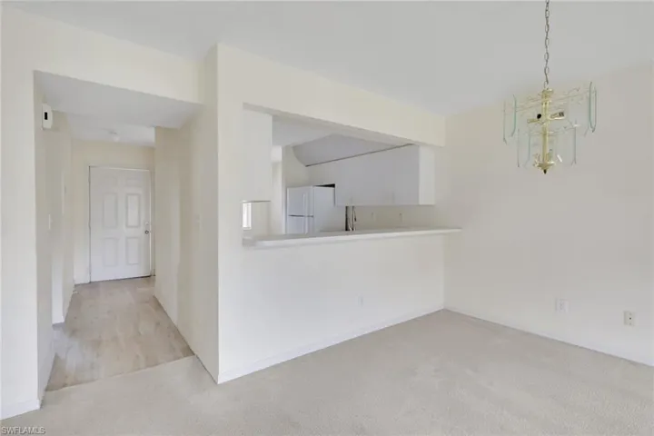 Unfurnished dining area with carpet floors and a chandelier