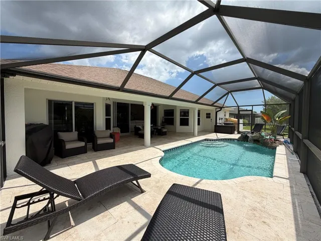 Screened lanai featuring large covered areas, a curved swimming pool with integrated steps and a rock waterfall