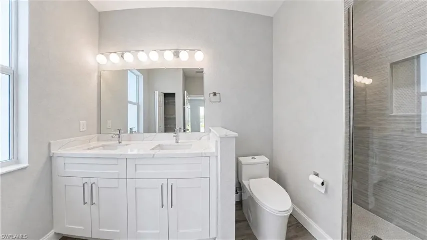 Dual vanity with white shaker-style cabinetry, a white countertop, and individual undermount sinks