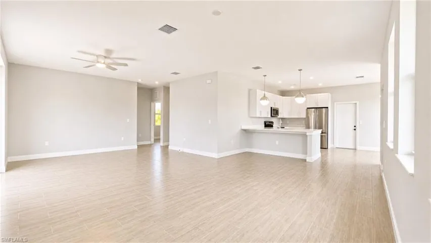 Open-concept living space featuring wood-finish flooring, recessed lighting, and a ceiling fan