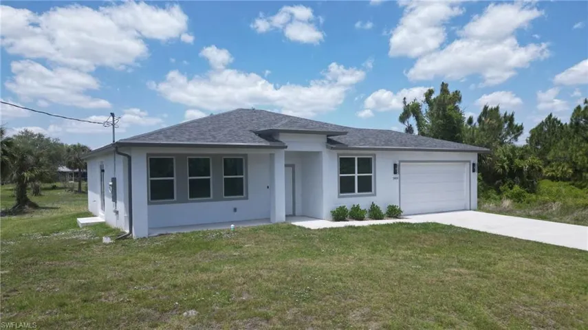 Contemporary one-story residence featuring a two-car garage, dark shingle roof, and a concrete driveway