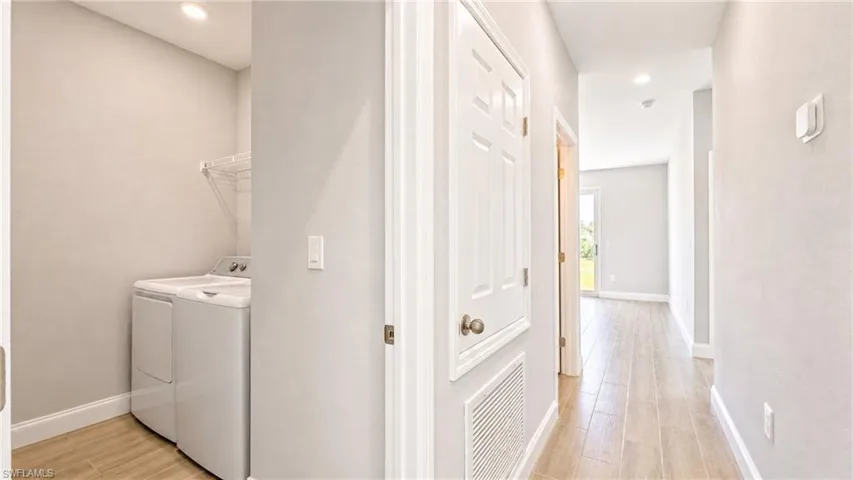 Dedicated laundry area with wire shelving and recessed lighting