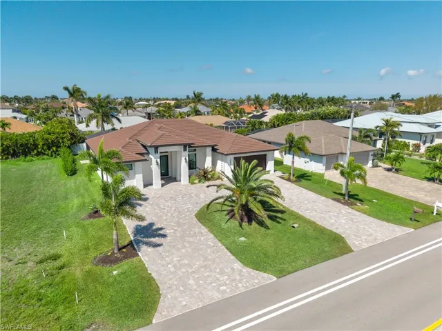 Mediterranean / spanish-style house with a front lawn, decorative driveway, stucco siding, a residential view, and a garage