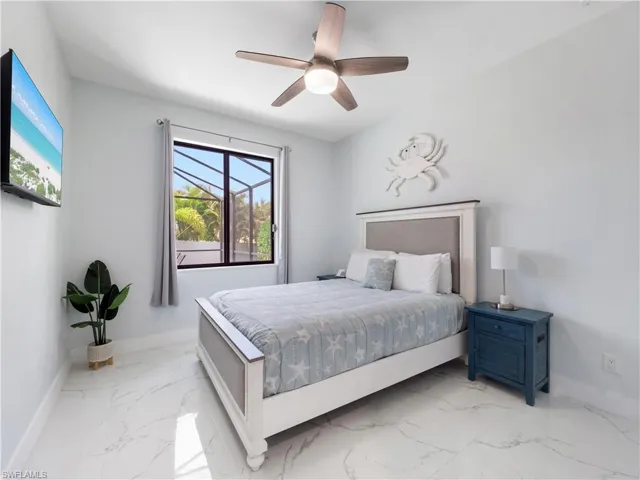 Bedroom featuring light marble finish floors and ceiling fan