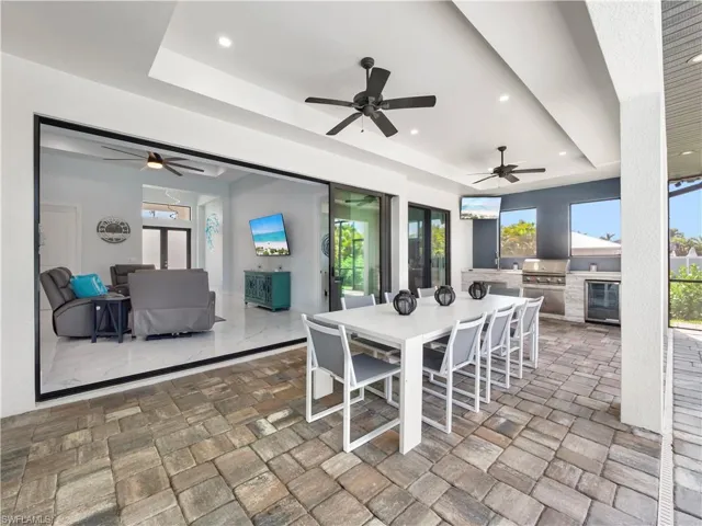 View of patio / terrace with an outdoor kitchen / dining area, french doors, beverage cooler, and ceiling fan
