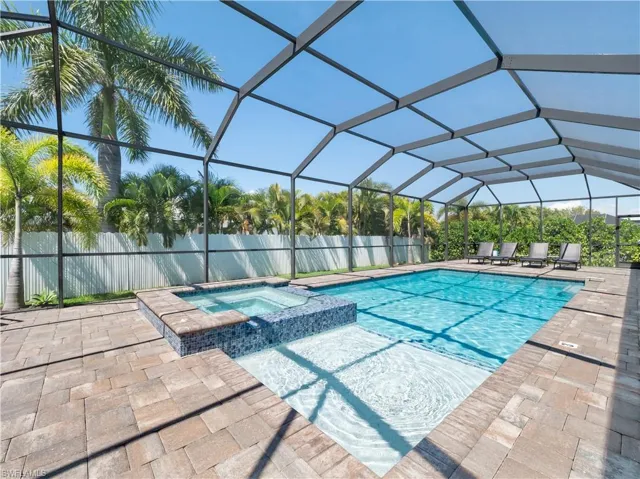 Relaxing pool / spa featuring a sunroom, a lanai, and a patio