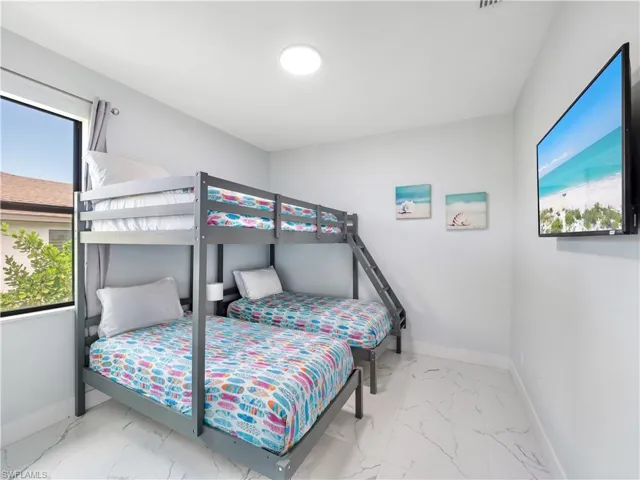 Bedroom with multiple windows and light marble finish floors