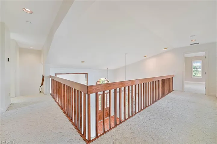 Corridor featuring visible vents, vaulted ceiling, carpet flooring, and recessed lighting