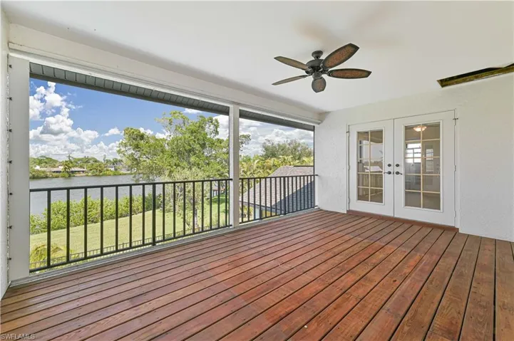 Deck with french doors, a water view, and ceiling fan