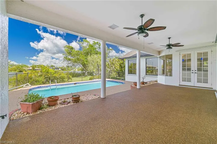 View of swimming pool with ceiling fan, a fenced backyard, french doors, a fenced in pool, and a patio area