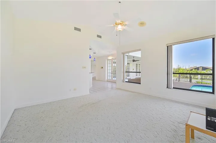 Unfurnished room with vaulted ceiling, baseboards, visible vents, and light colored carpet