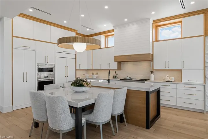 Kitchen with white cabinetry, pendant lighting, a center island with sink, recessed lighting, and decorative backsplash