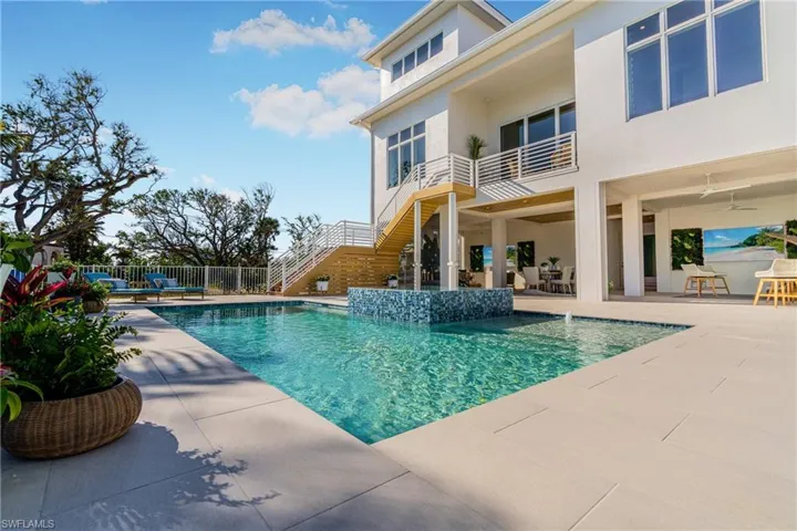 View of swimming pool with stairway, a patio area, a balcony, and outdoor dining area