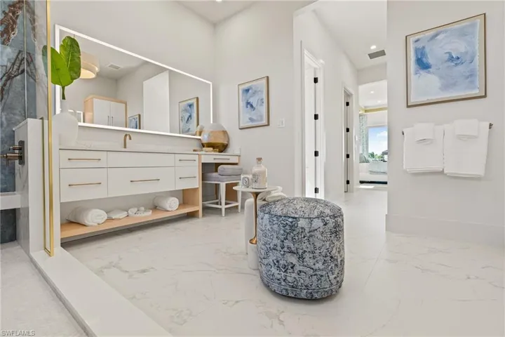 Full bath featuring vanity, light marble finish flooring, and recessed lighting