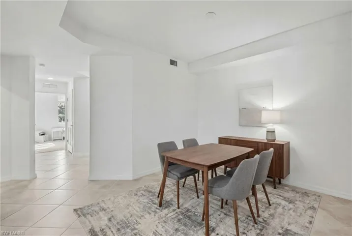 Dining space with baseboards and lighttile patterned floorsVirtually staged