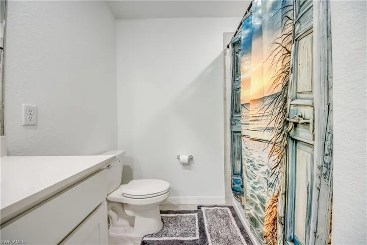 Bathroom with a stall shower, vanity, and a textured wall
