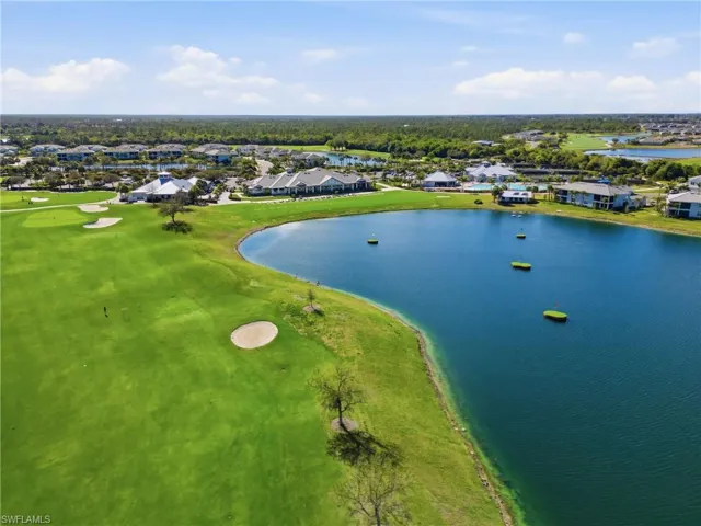 Aerial view of residential area featuring a nearby body of water and a local golf course