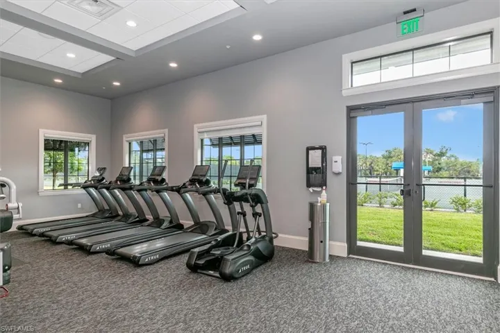 Gym featuring recessed lighting, french doors, and a high ceiling