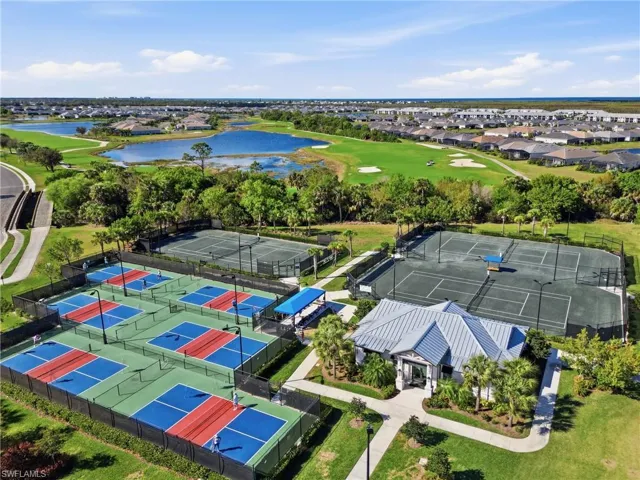 Aerial view of residential area featuring a nearby body of water and a local golf course