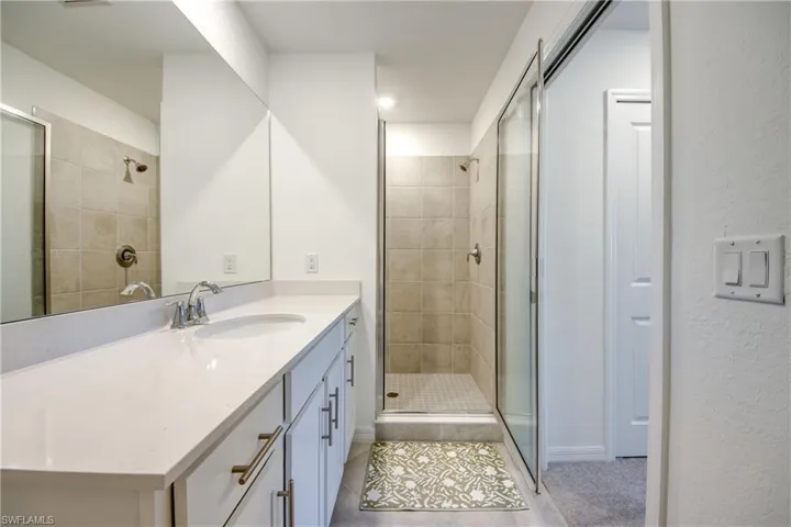 Full bath featuring vanity, a stall shower, and light tile patterned floors