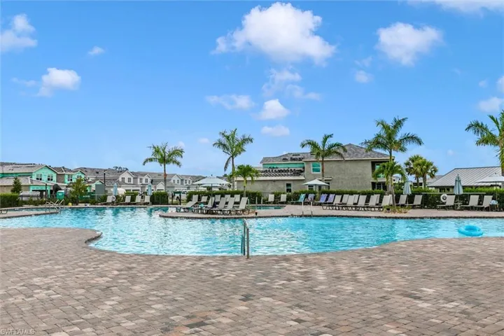 Community pool with a patio area and a residential view