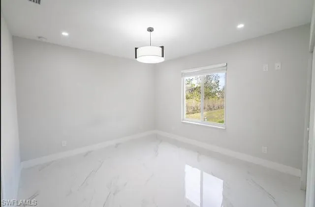 Spare room with recessed lighting and marble look tiles