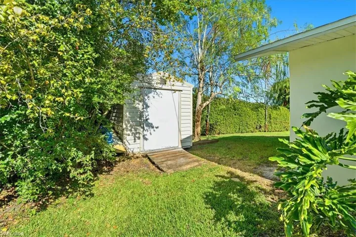 View of grassy yard featuring a shed