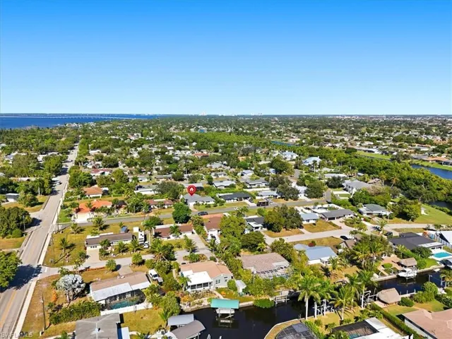 Aerial view of property's location featuring a nearby body of water and nearby suburban area