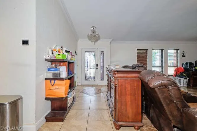Foyer featuring crown molding and light tile flooring
