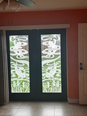 Doorway to outside with tile patterned flooring and ceiling fan