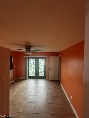 Tiled empty room featuring ceiling fan