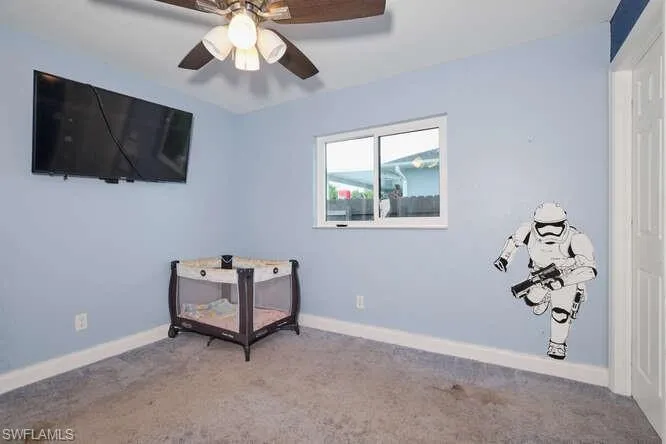 Carpeted bedroom featuring ceiling fan