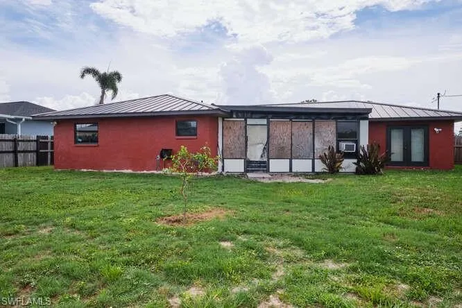 Back of property featuring a yard