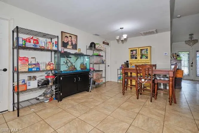 Dining space with a notable chandelier and light tile floors