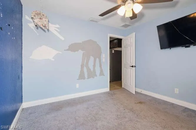 Carpeted spare room with ceiling fan