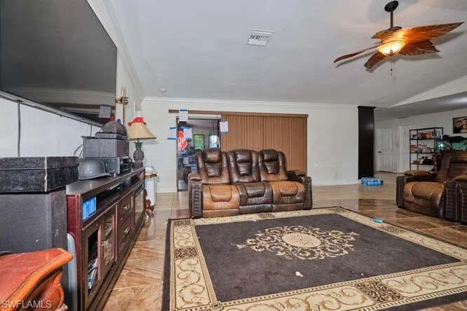 Living room featuring crown molding and ceiling fan