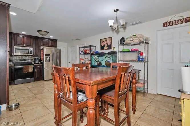 Dining room featuring light tile floors and an inviting chandelier