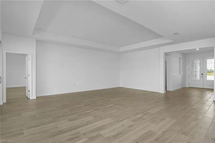 Welcoming foyer with double entry doors leading to open family living space.
