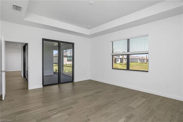 Owner suite includes sliders leading directly to outdoor living space.