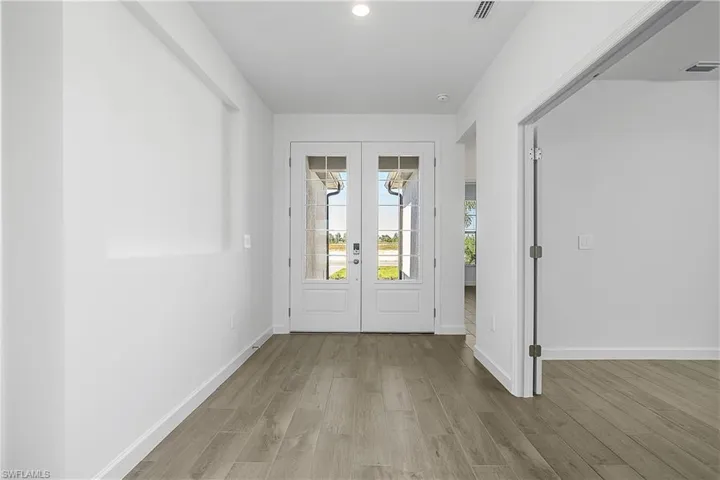 Wide and welcoming foyer entry with double doors.