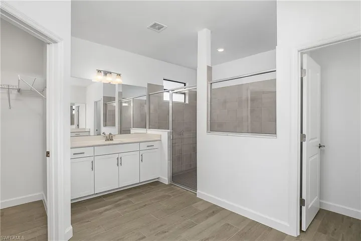 Oversized walk-in shower with two separate vanities.