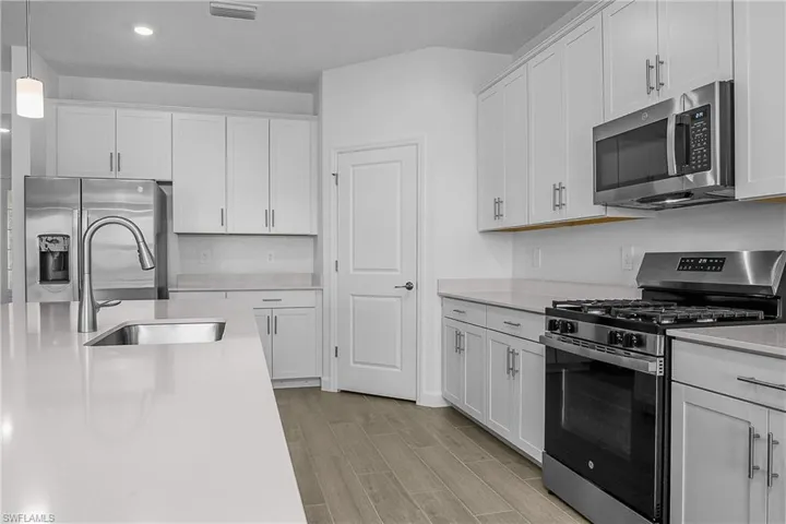 Spacious kitchen featuring natural gas stove, oversized island, walk-in pantry and quartz countertops.