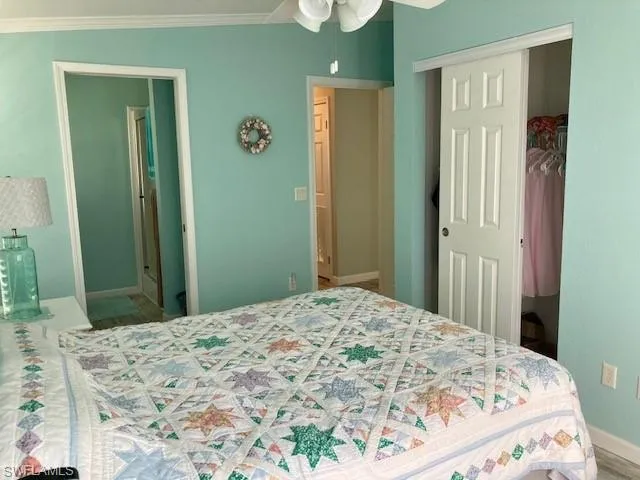 Bedroom featuring a closet, a ceiling fan, and crown molding