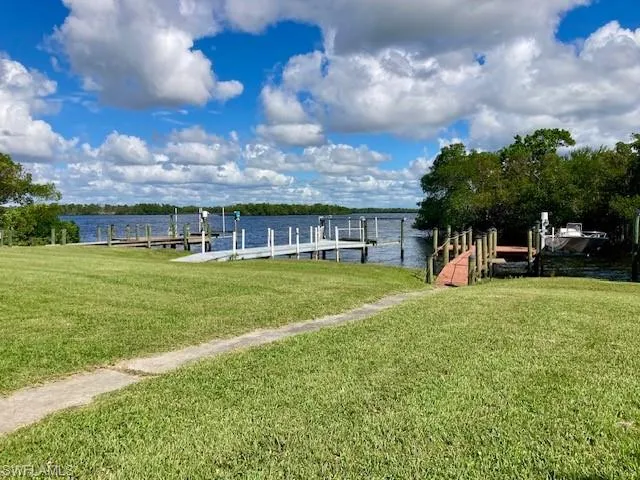 Dock with a water view and a lawn