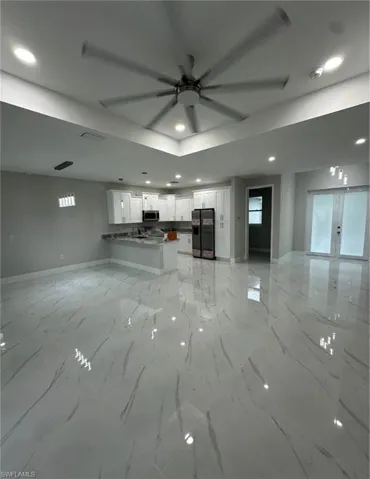 Unfurnished living room with a ceiling fan, french doors, and recessed lighting