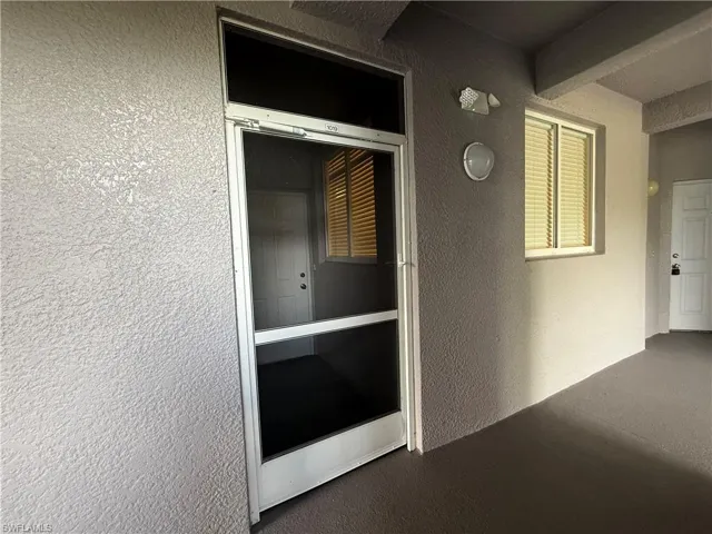 View of exterior entry featuring stucco siding