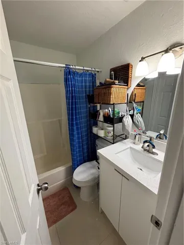 Laundry area featuring electric panel, separate washer and dryer, electric water heater, and cabinet space