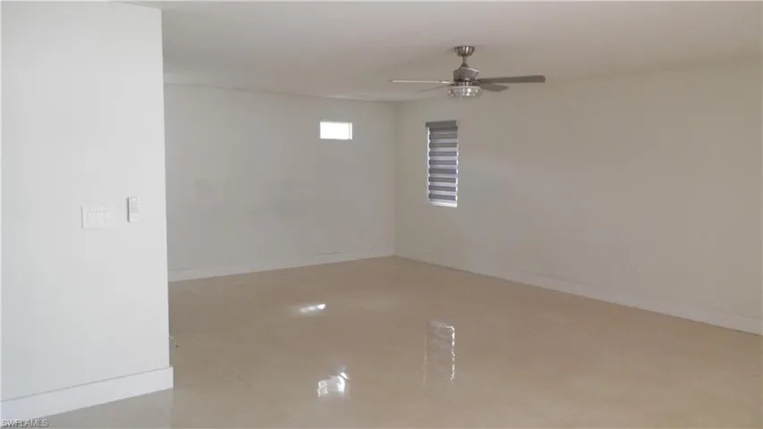 Spare room with baseboards and a ceiling fan