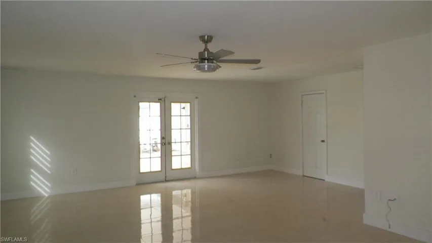 Unfurnished room with french doors, a ceiling fan, and light tile patterned floors