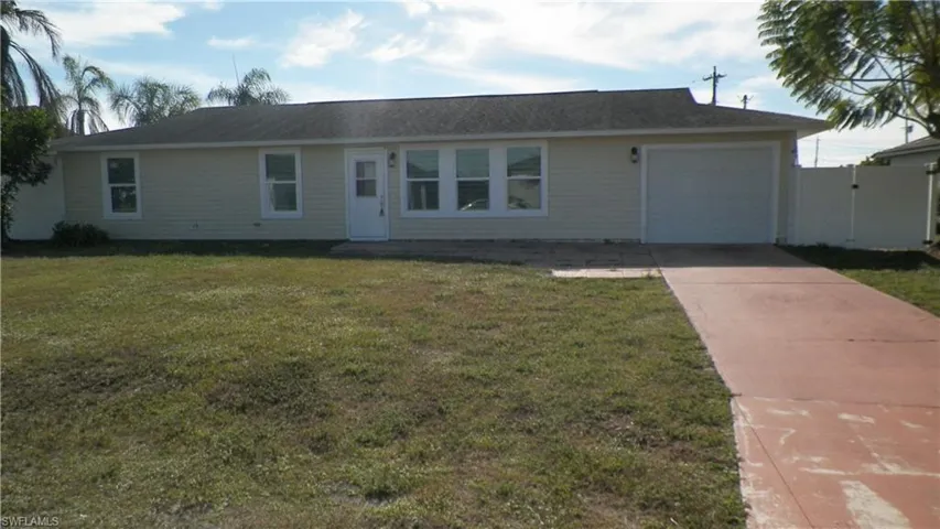 Ranch-style house featuring concrete driveway, a front lawn, and a garage
